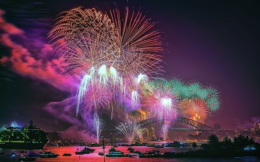 Обои на рабочий стол Фейерверк в ночном небе над мостом и кораблями