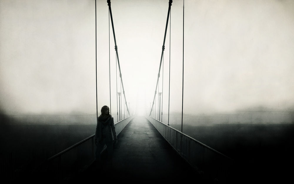 Обои для рабочего стола Мужчина стоит на мосту, уходящем в туман