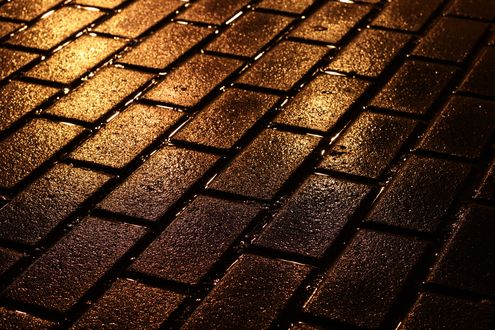 Обои на рабочий стол Мокрая от дождя брусчатка в огнях ночного города
