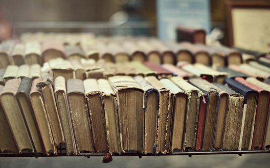 Обои на рабочий стол Старые книги в потрепанных переплетах стоят на столе