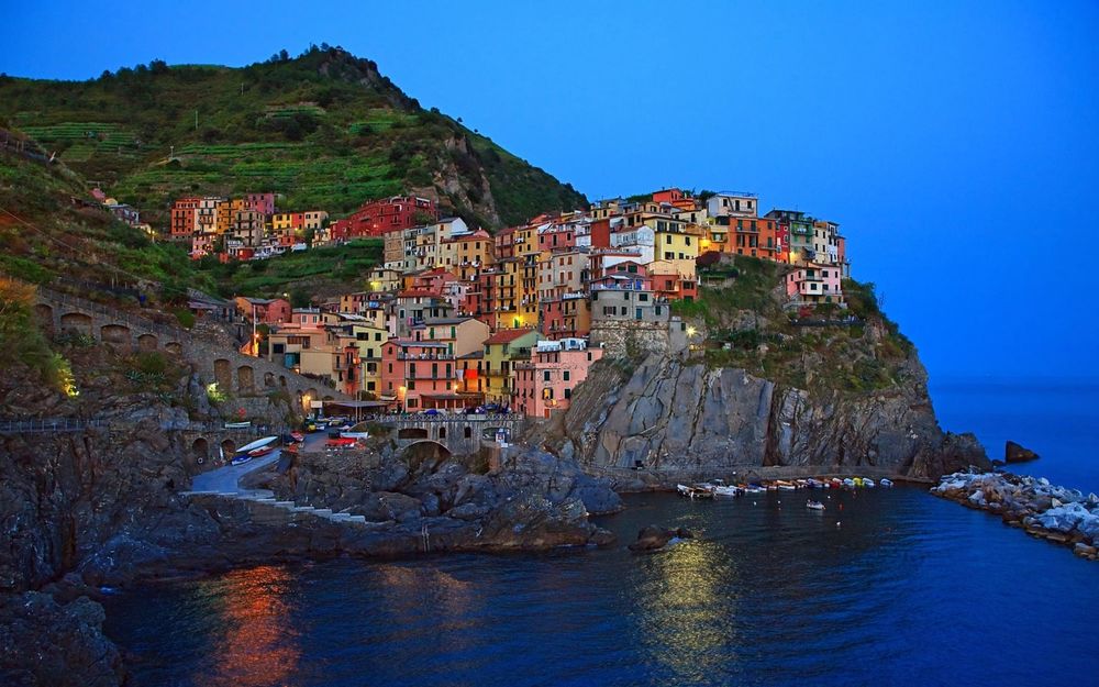 Обои для рабочего стола Небольшой рыбацкий городок Манарола, Италия / Manarola, Italy, расположенный на скале, нависающей над дикой береговой линией Средиземного моря / Mediterranean sea