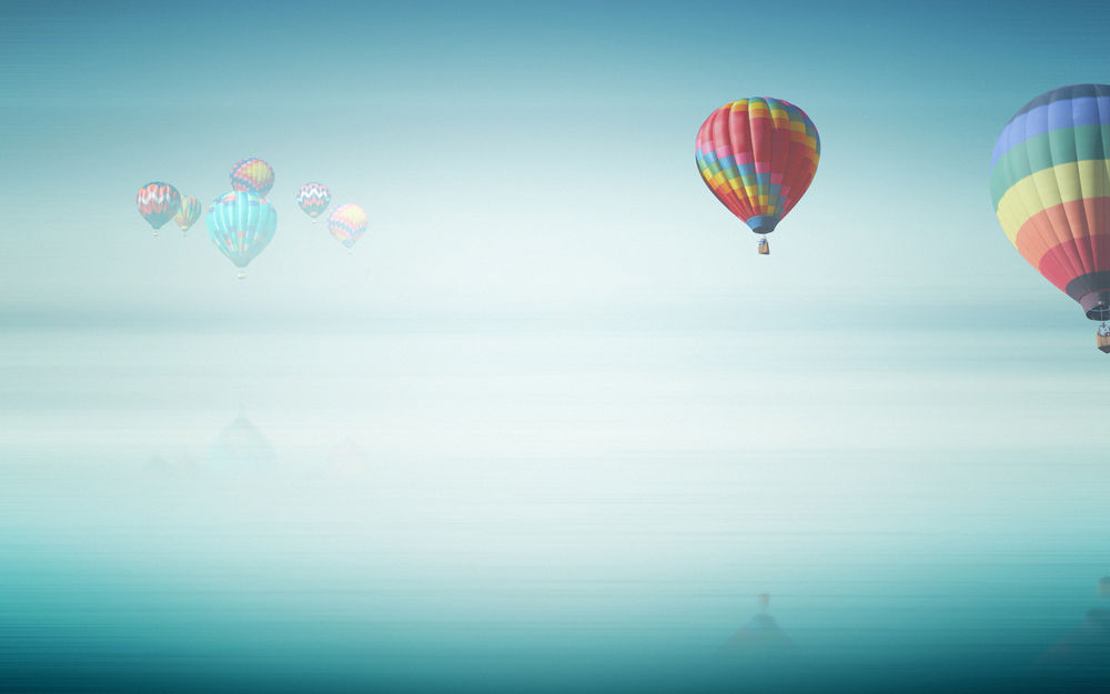 Обои для рабочего стола Воздушные шары летят высоко над городом в тумане