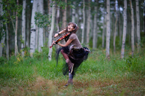 Обои на рабочий стол Линдси Стирлинг / Lindsey Stirling играет на скрипке в лесу