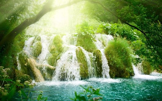 Обои на рабочий стол Водопад на фоне деревьев, на которые падают лучи солнца