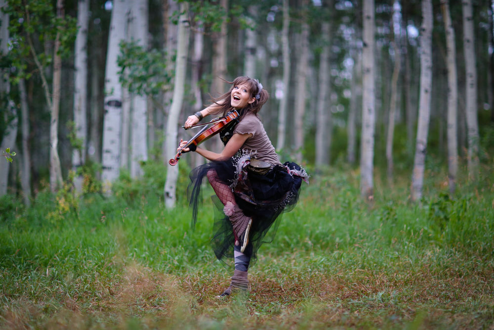 Обои для рабочего стола Линдси Стирлинг / Lindsey Stirling играет на скрипке в лесу