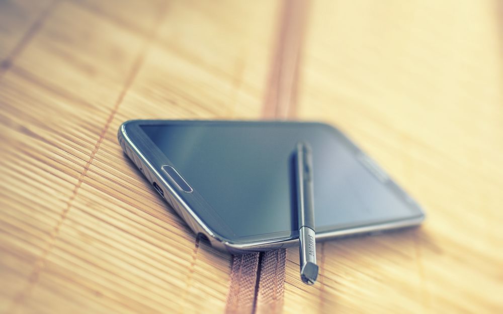 Обои для рабочего стола Стилус лежит на телефоне Samsung Note 2