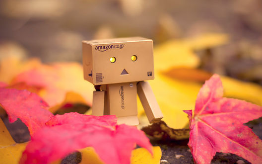 Обои на рабочий стол Коробочный человечек Данбо / Danbo стоит среди опавших осенних листьев