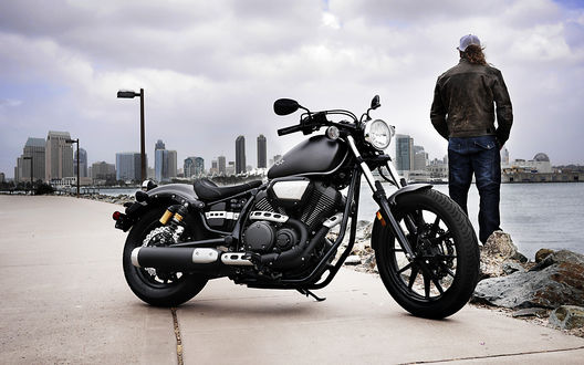 Обои на рабочий стол Мужчина, приехавший на мотоцикле Ямаха / Yamaha Star Bolt, остановился на берегу реки, любуясь городским видом