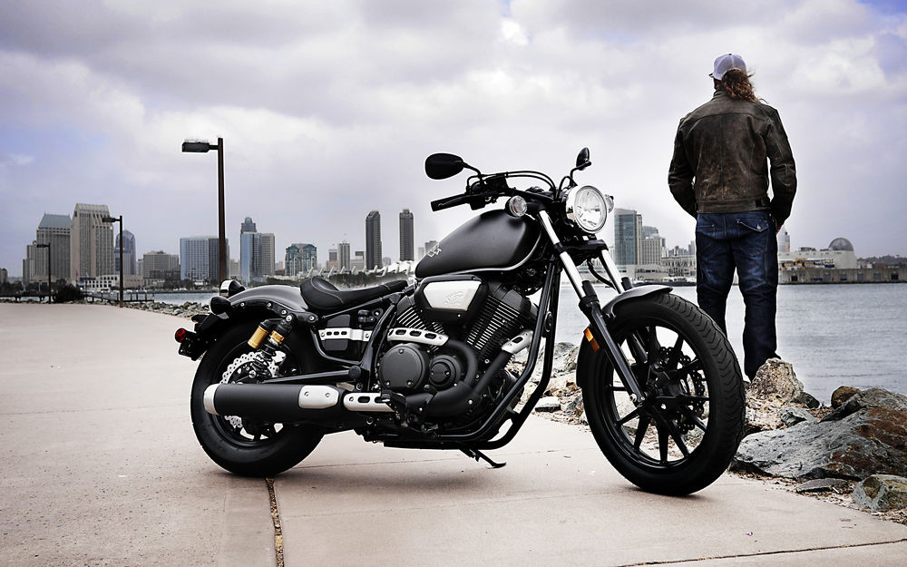 Обои для рабочего стола Мужчина, приехавший на мотоцикле Ямаха / Yamaha Star Bolt, остановился на берегу реки, любуясь городским видом