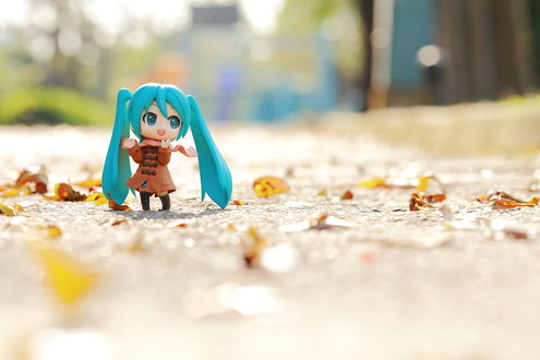 Обои на рабочий стол Маленькая фигурка Vocaloid Hatsune Miku / Вокалоид Хацуне Мику в плаще стоит на осенней дорожке
