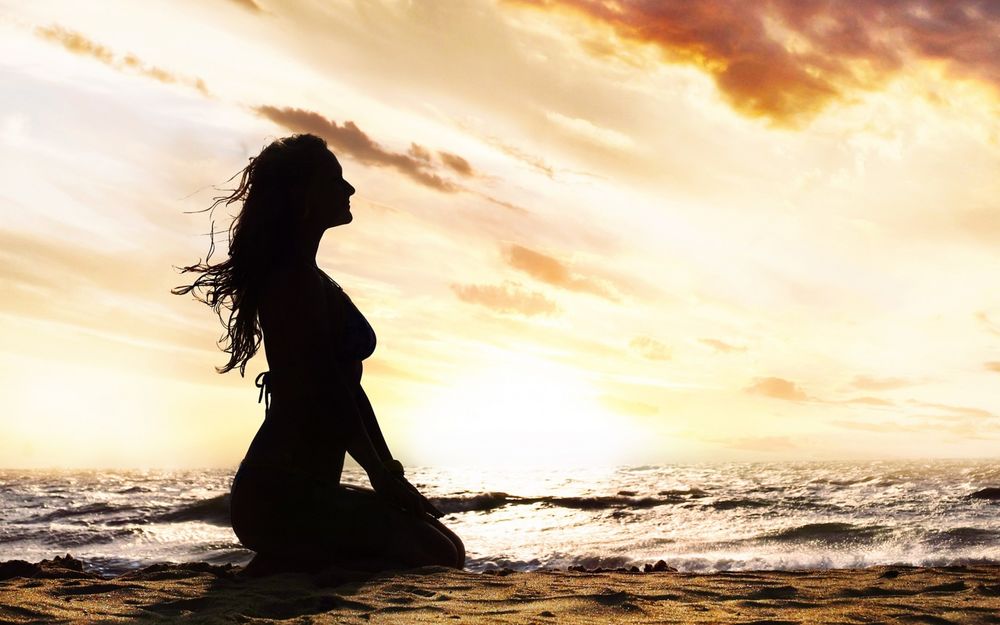 Девушка на берегу моря Привлекательная брюнетка в белой майке плещется в море