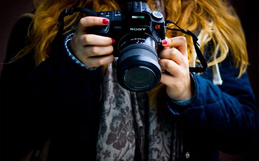 Обои на рабочий стол Девушка с фотоаппаратом Sony a 200 / Сони Альфа 200 в руках