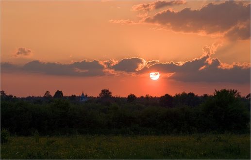 Обои на рабочий стол Закат над лесом и виднеющиеся купола небольшой церкви, фотограф Николай Шахманцир