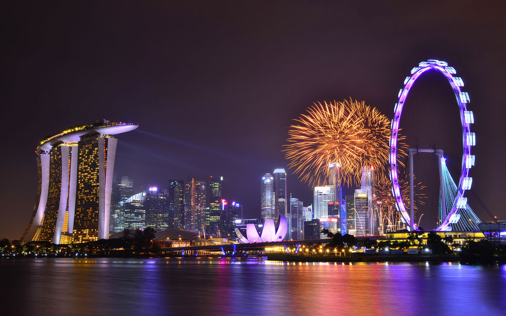 Обои для рабочего стола Светящийся город Сингапур / Singapore на берегу моря в ночное время