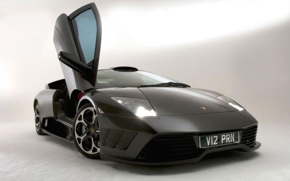 Обои для рабочего стола Lamborghini Murcielago / Ламборджини Мурселаго черного цвета с поднятой дверью стоит на белом фоне
