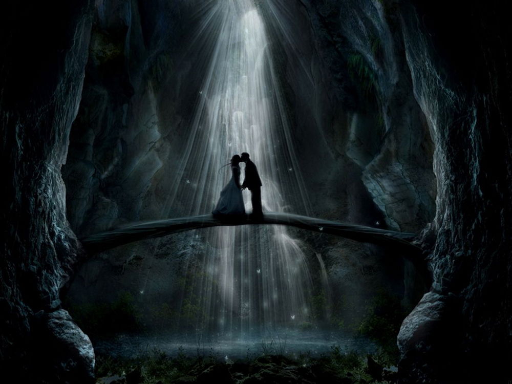 Обои для рабочего стола Целующиеся мужчина и женщина, стоящие на деревянном мостике в горном ущелье на фоне большого потока воды горного водопада