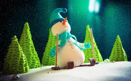 Обои на рабочий стол Фигурка снеговика на лыжах в лесу во время снегопада