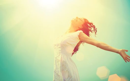 Обои на рабочий стол Смеющаяся девушка в лучах солнца