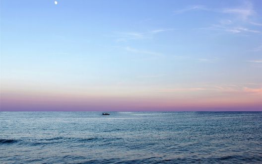 Обои на рабочий стол Одинокая лодка в море на рассвете