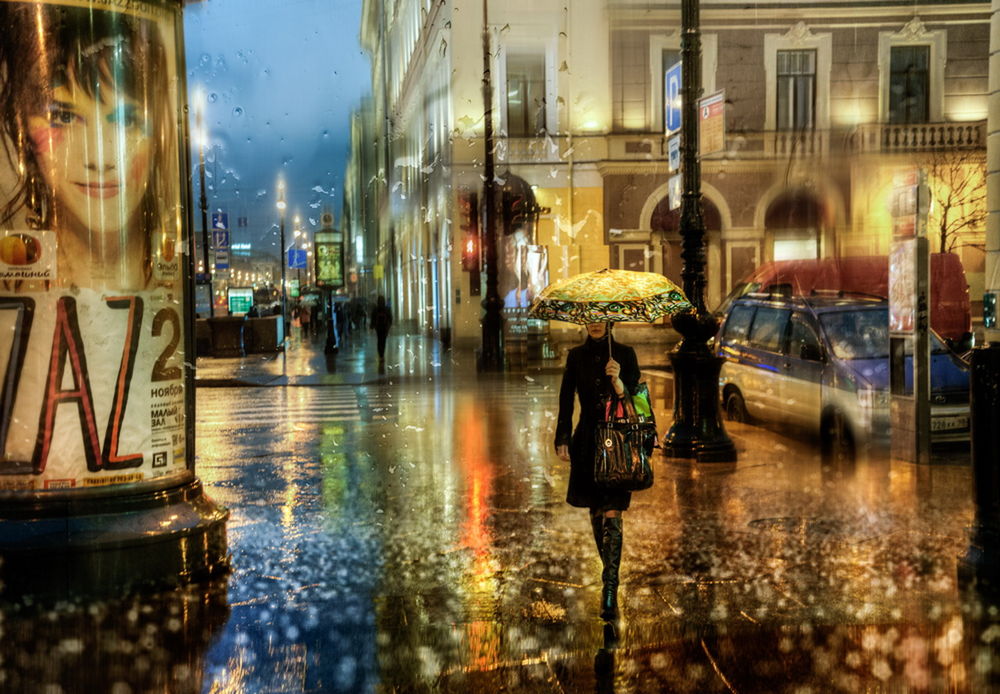 Обои для рабочего стола Стройная девушка с цветным зонтиком в руке, идущая под дождем по вечерним, городским улицам