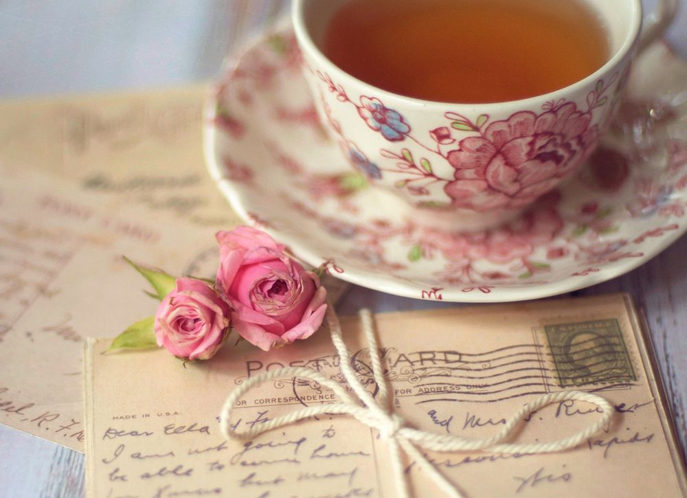 Обои для рабочего стола Чашка с чаем стоит на блюдце, рядом лежит письмо и два бутона роз