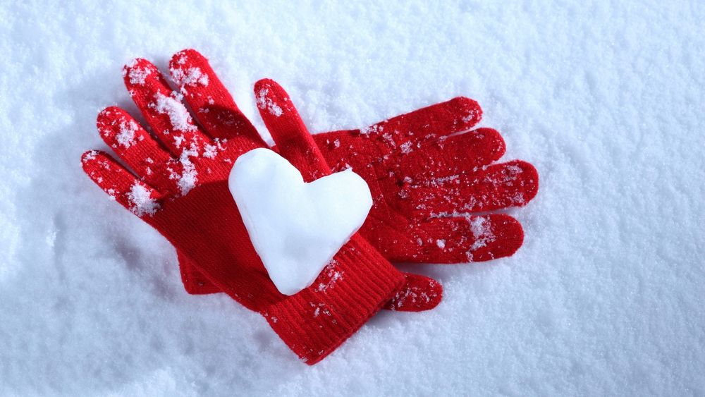 Обои для рабочего стола В красных перчатках сердце из снега