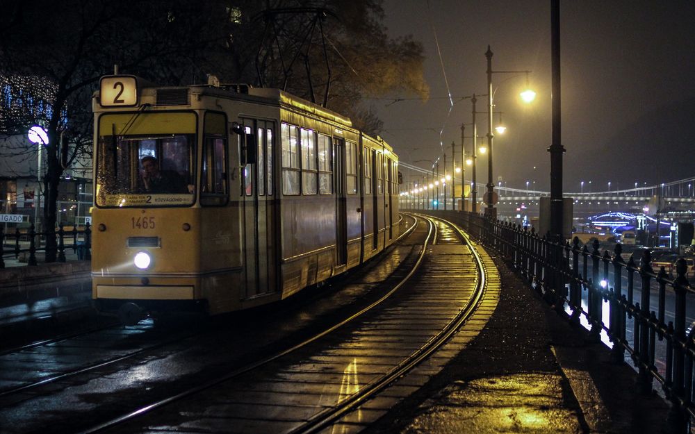 Обои для рабочего стола Трамвай едет по влажному после дождя ночному городу
