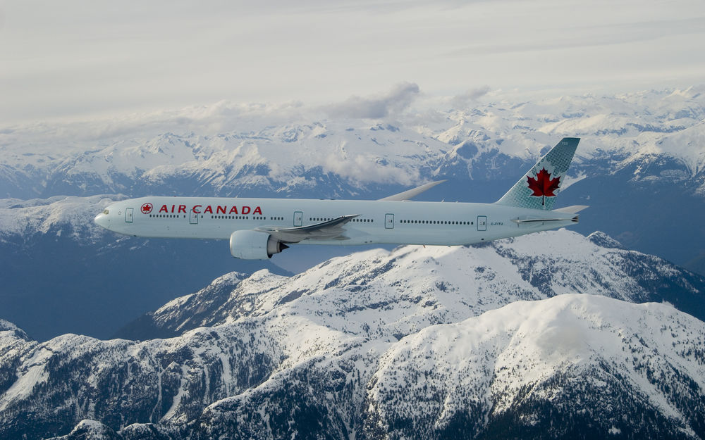 Обои для рабочего стола Под облаками летит боинг / boeing эир Канада / air Canada, прямо над заснеженными горами