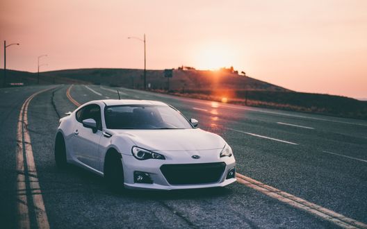 Обои на рабочий стол Белая Субару / Subaru стоит на дороге на фоне захода солнца