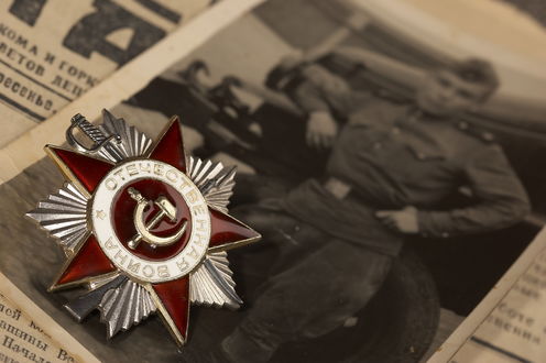 Обои на рабочий стол Значок Великая отечественная Война лежит на староq черно-белой фотографии