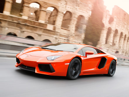 Обои на рабочий стол Оранжевый Lamborghini / Ламборгини Aventador едет по дороге