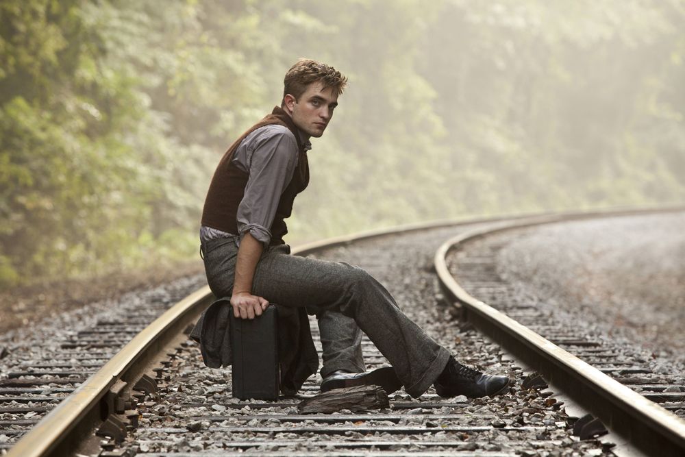 Обои для рабочего стола Актер Роберт Паттинсон / Robert Pattinson сидит на чемодане на рельсах, ожидая поезда