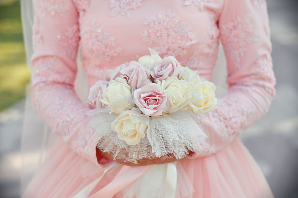 Обои для рабочего стола Девушка в розовом свадебном платье держит свадебный букет цветов
