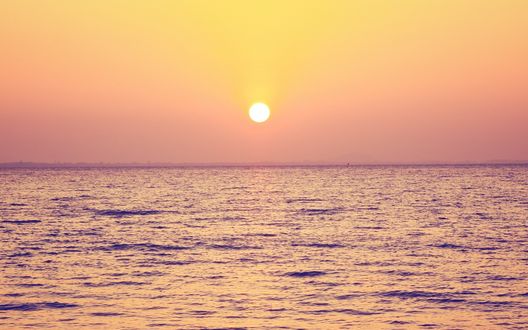 Обои на рабочий стол Спокойное море на фоне оранжевого заката