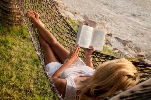 Обои на рабочий стол Девушка лежит в гамаке и читает книгу