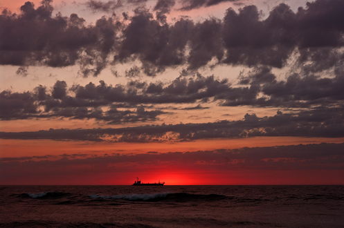 Обои на рабочий стол Корабль, плывущий по морю на линии горизонта