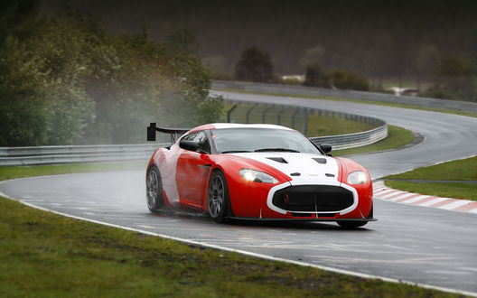 Обои на рабочий стол Красно-белый Aston Martin V12 Zagato едет по мокрой дороге