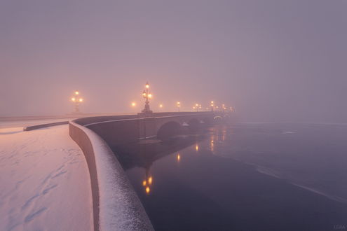 Обои на рабочий стол Каменный мост с лежащим на нем снегом, проложенный через незамерзающую реку с горящими фонарями на фоне утреннего небосклона, покрытого густой, туманной дымкой, автор EGRA