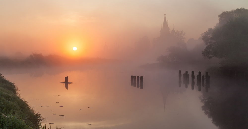 Обои для рабочего стола Молочный туман опустился на реку на фоне утреннего, восходящего солнца
