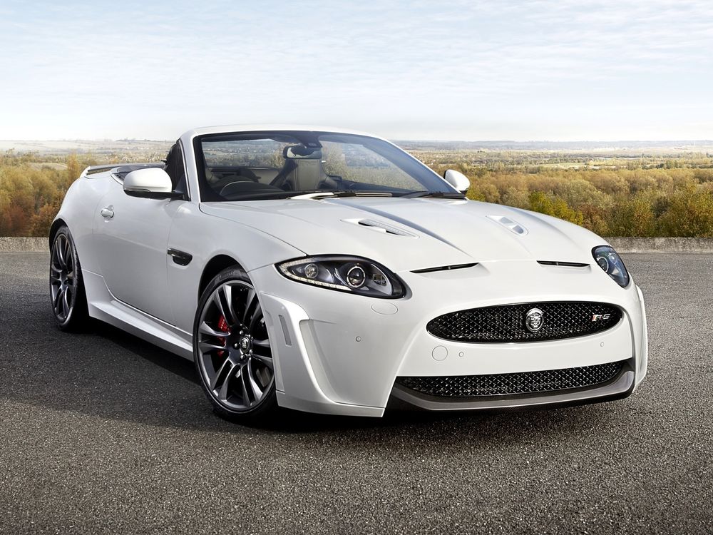 Обои для рабочего стола Белый кабриолет Jaguar xkr-s стоит на асфальте
