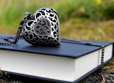 Обои на рабочий стол Кулон в виде сердца лежит на книге