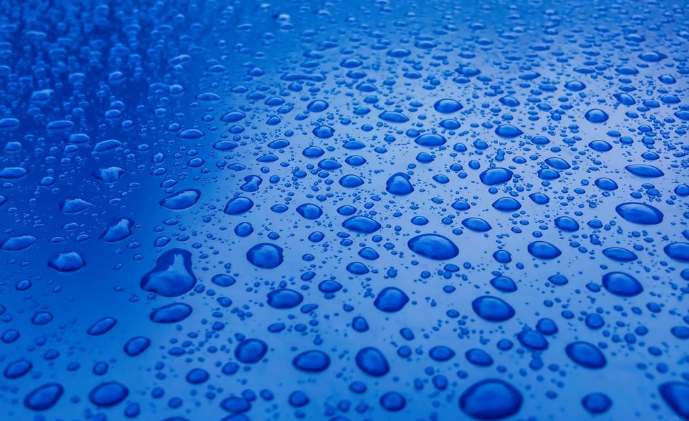 Обои для рабочего стола Капли воды на голубой поверхности