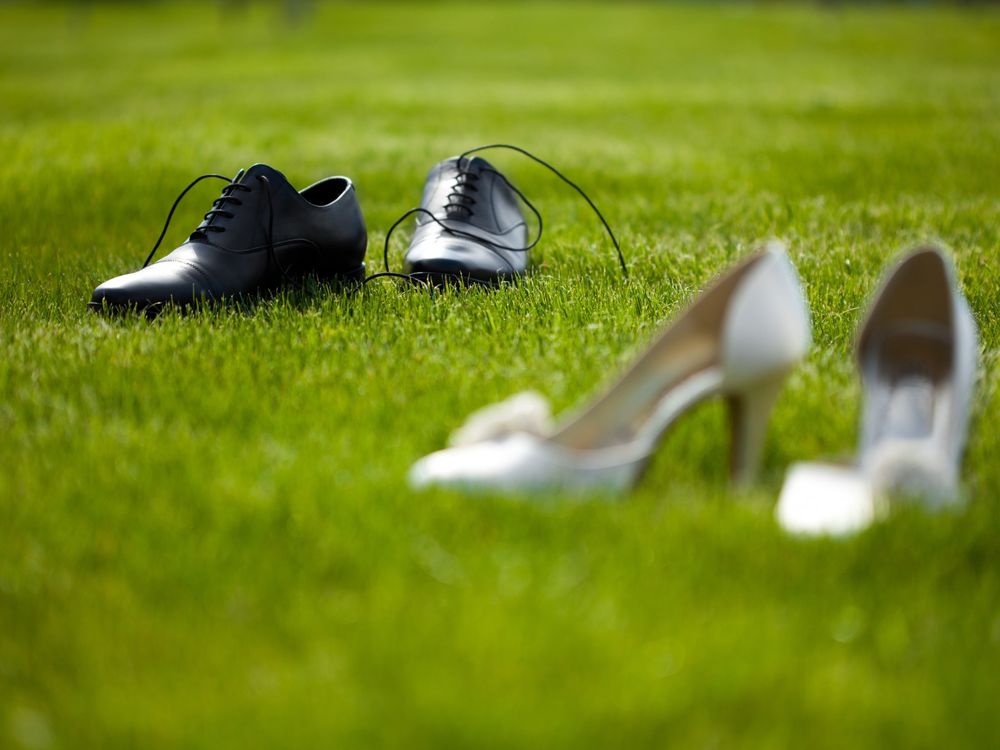 Обои для рабочего стола Мужские ботинки и женские туфли стоят на зеленой траве