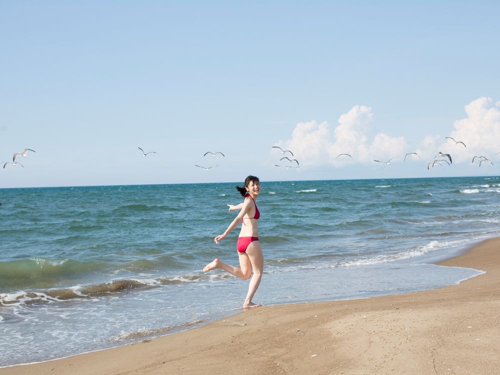 Обои для рабочего стола Японская певица, участница группы C-ute, Яджима Майми / Yajima Maimi одетая в красный бикини бежит по береговой линии моря, а небе летают чайки