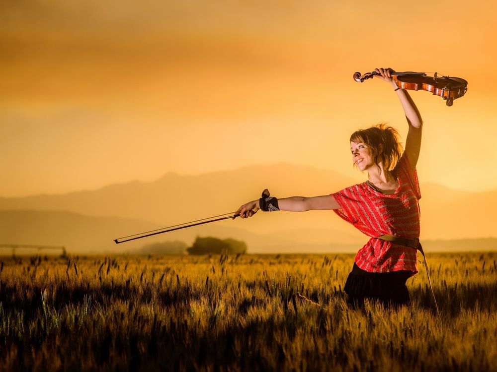 Обои для рабочего стола Американская скрипачка Линдси Стирлинг / Lindsey Stirling со скрипкой в поле