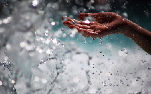 Обои на рабочий стол Рука девушки ловит капли воды