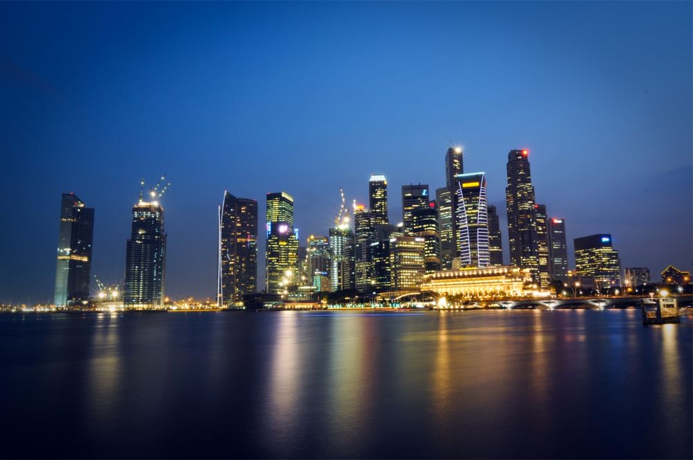 Обои для рабочего стола Светящийся город Сингапур / Singapore на берегу моря в ночное время