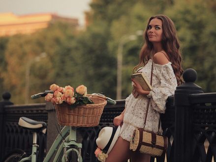 Обои на рабочий стол Девушка с книгой стоит у велосипеда, на котором корзина с цветами, фотограф Яна Ультра
