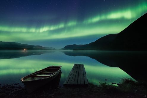 Обои на рабочий стол Лодка у берега возле деревянного мостика на фоне сияния в небе, которое отражается в воде, by Trichardsen