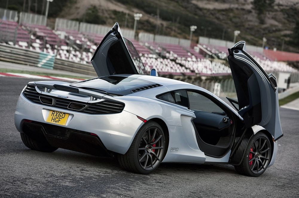 Обои для рабочего стола Суперкар McLaren MP4-12C, стоящий на стадионе